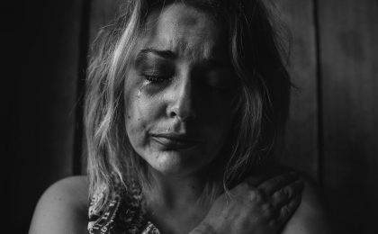 grayscale photo of woman crying holding her right chest
