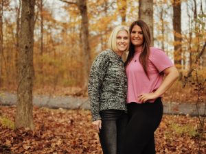 two women posing for a picture in the woods