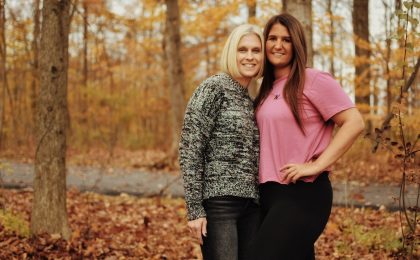 two women posing for a picture in the woods